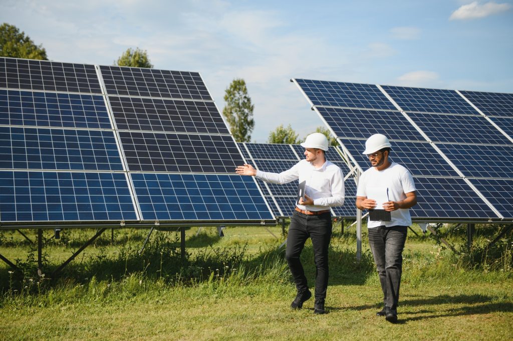 The solar farm, solar panel with two engineers walk to check the operation of the system